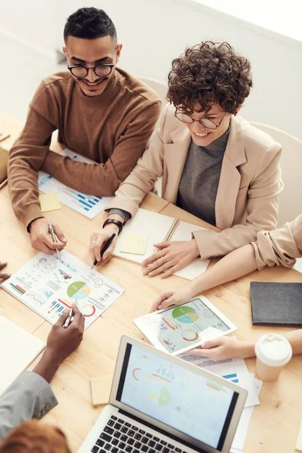Two colleagues collaborate on a marketing strategy using a whiteboard, focusing on user-generated content.